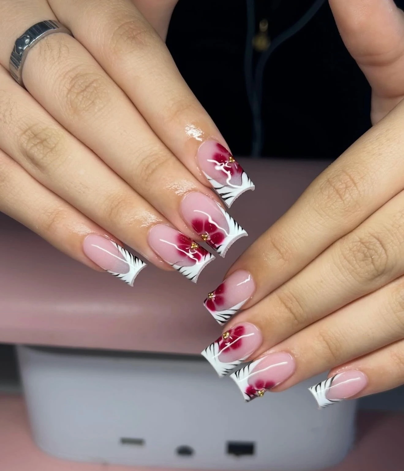 Red hibiscus flowers and black-and-white striped French tips