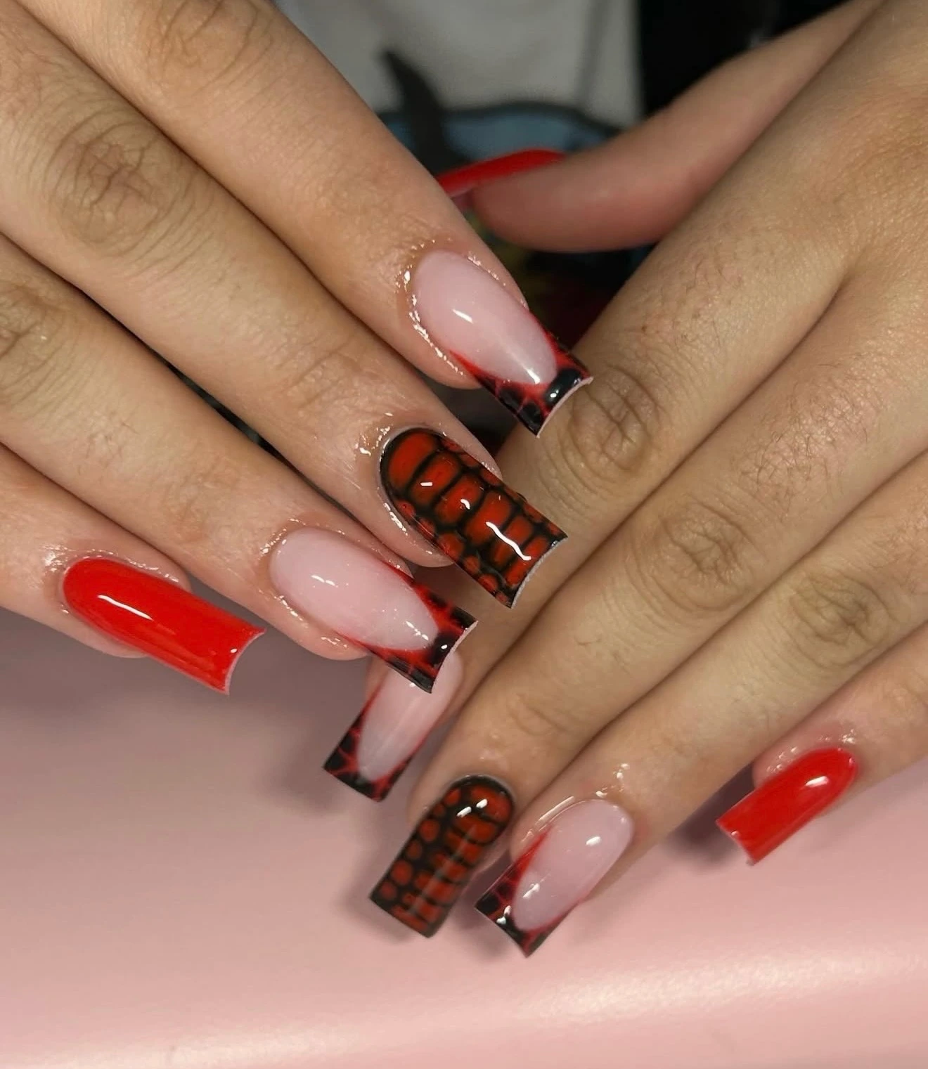 Glossy red and black nail art with nude French tips, by Joyful Expressions